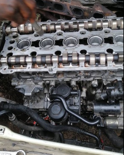 Stripped cylinder head with camshafts exposed during an engine overhaul